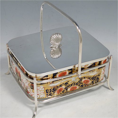 An Antique Victorian Silver Plated and fine China sardine dish, having a rectangular bone China body with hand-painted gold, blue, and orange scroll and floral decoration, all sitting in a plain wire-work galleried frame, a lift-off lid with cast conch shell finial, a plain handle, and all sitting on four wire-work feet, and with a pair of antique silver-plated sardine server tongs in the Kings pattern. The sardine dish made by James Dixon & Sons of Sheffield in ca. 1890. The dimensions of this fine hand-made antique silver-plated and bone China sardine dish are length 14 cms (5.5 inches), width 12 cms (4.75 inches), and height (excluding handles) 7 cms (2.75 inches).