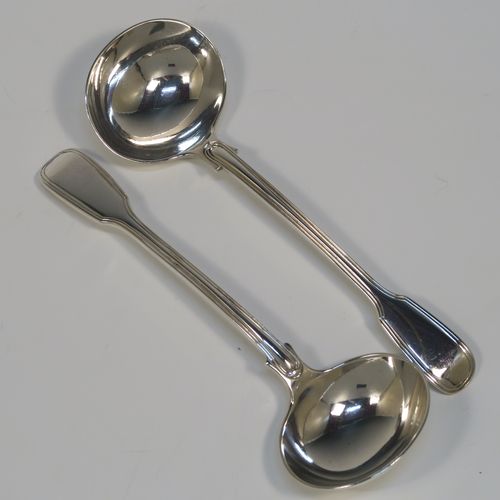 A beautiful Antique Victorian Sterling Silver pair of sauce ladles in the double-struck Fiddle and Thread pattern, having oval bowls. These elegant silver sauce ladles were made by the most important Victorian cutlery maker, George Adams, of London in 1845. The dimensions of this fine pair of hand-made antique silver sauce ladles are length 18.5 cms (7.25 inches), and they weigh a total of approx. 148g (4.8 troy ounces).   