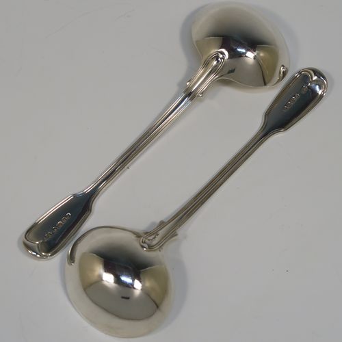 A beautiful Antique Victorian Sterling Silver pair of sauce ladles in the double-struck Fiddle and Thread pattern, having oval bowls. These elegant silver sauce ladles were made by the most important Victorian cutlery maker, George Adams, of London in 1845. The dimensions of this fine pair of hand-made antique silver sauce ladles are length 18.5 cms (7.25 inches), and they weigh a total of approx. 148g (4.8 troy ounces).