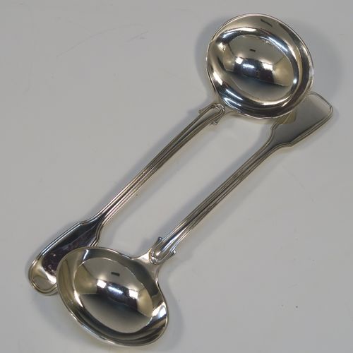 A beautiful Antique Victorian Sterling Silver pair of sauce ladles in the double-struck Fiddle and Thread pattern, having oval bowls. These elegant silver sauce ladles were made by the most important Victorian cutlery maker, George Adams, of London in 1845. The dimensions of this fine pair of hand-made antique silver sauce ladles are length 18.5 cms (7.25 inches), and they weigh a total of approx. 148g (4.8 troy ounces).