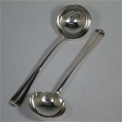 A very handsome Antique Edwardian Sterling Silver pair of Sauce Ladles in the Hollow-Ribbed Rattail pattern, and having round bowls. These elegant antique silver sauce ladles were made by Johnson, Walker, and Tolhurst of London in 1908. The dimensions of this fine pair of hand-made silver sauce ladles are length 18 cms (7 inches), and they weigh a total of approx. 136g (4.4 troy ounces).