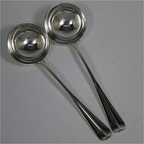 A very handsome Antique Edwardian Sterling Silver pair of Sauce Ladles in the Hollow-Ribbed Rattail pattern, and having round bowls. These elegant antique silver sauce ladles were made by Johnson, Walker, and Tolhurst of London in 1908. The dimensions of this fine pair of hand-made silver sauce ladles are length 18 cms (7 inches), and they weigh a total of approx. 136g (4.4 troy ounces).
