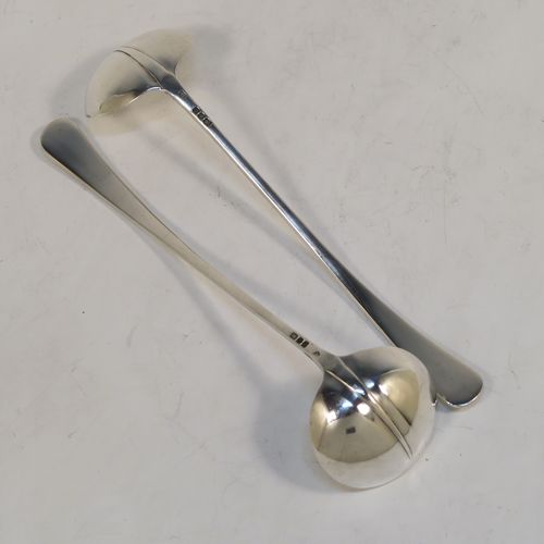 An unusual pair of long-handled Sterling Silver sauce or cream Ladles in the Rattail Hanoverian pattern, having plain round bowls, and long plain handles. This elegant pair of silver ladles were made by Robert Comyns of London in 1975. The dimensions of this fine pair of hand-made silver cream or sauce ladles are length 18 cms (7 inches), and they weigh a total of approx. 98g (3.2 troy ounces).
