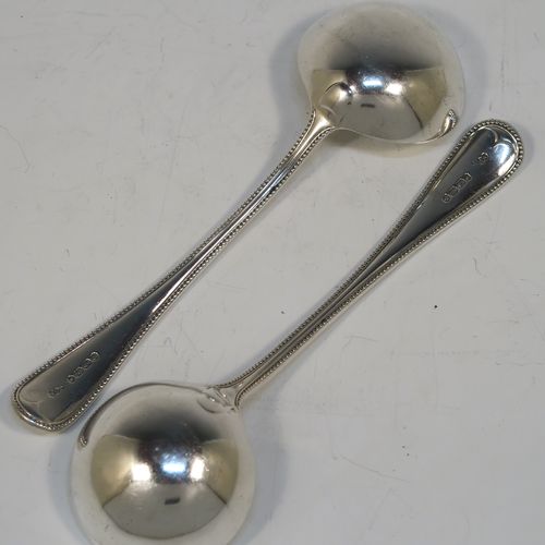 A beautiful Antique Victorian Sterling Silver pair of sauce ladles in the double-struck bead pattern, having round bowls. These elegant silver sauce ladles were made by the most important Victorian cutlery maker, George Adams, of London in 1864. The dimensions of this fine pair of hand-made antique silver sauce ladles are length 18.5 cms (7.25 inches), and they weigh a total of approx. 157g (5 troy ounces).  