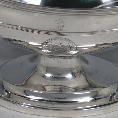 An Antique Georgian Sterling Silver pair of heavy sauce tureens, having oval neoclassical boat-shaped bodies with applied reeded borders, with cast reeded loop handles, and all sitting on cast oval pedestal feet. Made by Cornelius Bland y of London in 1792. The dimensions of this fine hand-made antique silver pair of sauce tureens are height 14 cms (5.5 inches), length 24.5 cms (9.75 inches), width 11 cms (4.25 inches), with a total weight of approx. 960g (31 troy ounces). Please note that both theses items are crested.