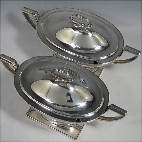 An Antique Georgian Old Sheffield silver-plated pair of Neoclassical sauce tureens, having oval boat-shaped bodies with applied reeded borders, with cast reeded side-handles, original domed lids with asparagus loop handles, and all sitting on pedestal feet with rectangular bases. Made in ca. 1790 in the Old Sheffield fused plate. The dimensions of this fine hand-made antique Old Sheffield silver plated pair of sauce tureens are height 14 cms (5.5 inches), length 23 cms (9 inches), and width 11 cms (4.25 inches).