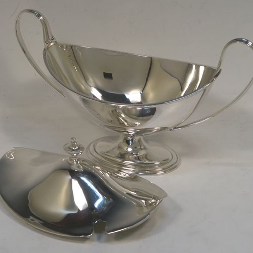 A very elegant Sterling Silver pair of sauce tureens with covers, having plain oval neoclassical boat-shaped bodies with applied reeded borders, pull-off lids with cast finials, with reeded loop side-handles, and all sitting on pedestal feet. These beautiful silver sauce tureens were made by Thomas Bradbury of Sheffield in 1931. The dimensions of this fine hand-made silver2 pair of sauce tureens are height 13.5 cms (5.5 inches), length 23 cms (9 inches), width 10 cms (4 inches), with a total weight of approx. 853g (27.5 troy ounces).