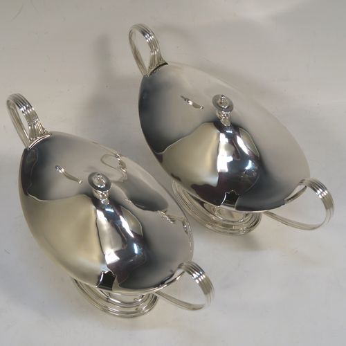 A very elegant Sterling Silver pair of sauce tureens with covers, having plain oval neoclassical boat-shaped bodies with applied reeded borders, pull-off lids with cast finials, with reeded loop side-handles, and all sitting on pedestal feet. These beautiful silver sauce tureens were made by Thomas Bradbury of Sheffield in 1931. The dimensions of this fine hand-made silver2 pair of sauce tureens are height 13.5 cms (5.5 inches), length 23 cms (9 inches), width 10 cms (4 inches), with a total weight of approx. 853g (27.5 troy ounces).