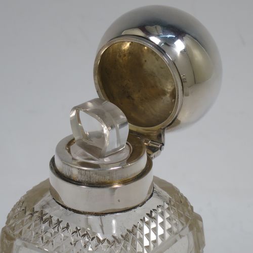 A very pretty and unusual pair of Antique Victorian Sterling Silver and hand-cut crystal table scent bottle, having plain round mounts  with hinged lids, gold-gilt interiors and internal stoppers. The crystal bodies with square cross-sections and tapering sides having clear side panels and hobnail cut edges, and all sitting on star-cut bases. Made by John Grinsell and Co., of London in 1898. The dimensions of these fine hand-made antique silver and crystal scent bottles are height 14.5 cms (5.75 inches), and 7cms (2.75 inches) square at base.    