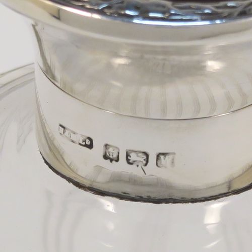 A very pretty Sterling Silver and inlaid tortoise-shell hand-cut crystal table scent bottle, having a plain round mount, a hinged lid with an inlaid tortoise-shell cover, an internal stopper, and hand-cut main body with reeding and star-cut decoration. This beautiful silver and crystal scent bottle was made by Hasset and Harper Ltd., of Birmingham in 1921. The dimensions of this fine hand-made silver and tortoise shell scent bottle are height 10 cms (4 inches), and diameter 9 cms (3.5 inches).