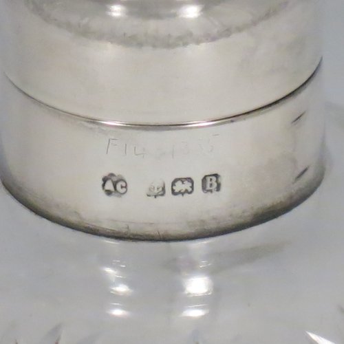 A Sterling Silver and hand-cut crystal table scent bottle, having a plain round mount, a hinged lid with a blue enamelled top, an internal stopper, and hand-cut main body with reeding and star-cut  decoration. Made by Albert Carter of Birmingham in 1926. The dimensions of this fine hand-made silver and enamelled scent bottle are height 11 cms (4.25 inches), and diameter 9 cms (3.5 inches).    
