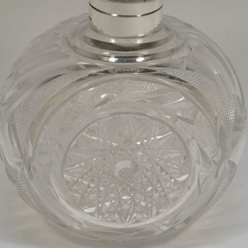 A very large and pretty pair of Antique Victorian Sterling Silver and hand-cut crystal table scent bottles, having hinged lids with gold-gilt interiors and hand-chased floral decoration, with removable internal stoppers, and hand-cut crystal main bodies. These beautiful antique silver and crystal scent bottles were made by Alfred Fuller of London in 1892. The dimensions of these fine hand-made antique silver and crystal scent bottles are height 18.5 cms (7.25 inches), width 12.5 cms (5 inches), and depth 9 cms (3.5 inches).