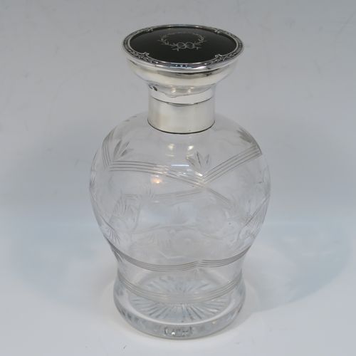 A very beautiful Sterling Silver and inlaid tortoise-shell hand-cut crystal table scent bottle, having a plain round mount, a hinged lid with an inlaid tortoise-shell cover, an internal stopper, a round main body with frosted cut floral hand-engraving and bands of reeded decoration, and siting on a flat base with hand-engraved star-cut work. This pretty silver and crystal scent bottle was made by Henry Matthew of Birmingham in 1928. The dimensions of this fine hand-made silver and tortoise shell scent bottle are height 14 cms (5.5 inches), and diameter 8.5 cms (3.3 inches).   