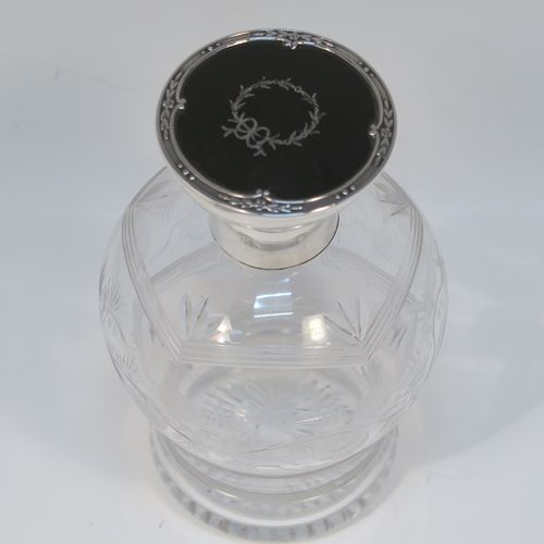 A very beautiful Sterling Silver and inlaid tortoise-shell hand-cut crystal table scent bottle, having a plain round mount, a hinged lid with an inlaid tortoise-shell cover, an internal stopper, a round main body with frosted cut floral hand-engraving and bands of reeded decoration, and siting on a flat base with hand-engraved star-cut work. This pretty silver and crystal scent bottle was made by Henry Matthew of Birmingham in 1928. The dimensions of this fine hand-made silver and tortoise shell scent bottle are height 14 cms (5.5 inches), and diameter 8.5 cms (3.3 inches).