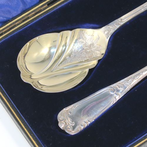 A beautiful pair of Antique Edwardian Sterling Silver serving spoons, having handles with double-struck floral and scroll-work in a Louis style pattern handles, and fluted oval bowls with a gold-gilt wash and hand-engraved floral work, all in their original dark blue satin and velvet-lined presentation box. These wonderful silver serving spoons were made by Thomas Brabury of Sheffield in 1910. The dimensions of this fine hand-made pair of antique silver serving spoons are length 19cms (7.5 inches), and they weigh a total of approx. 97g (3 troy ounces).
