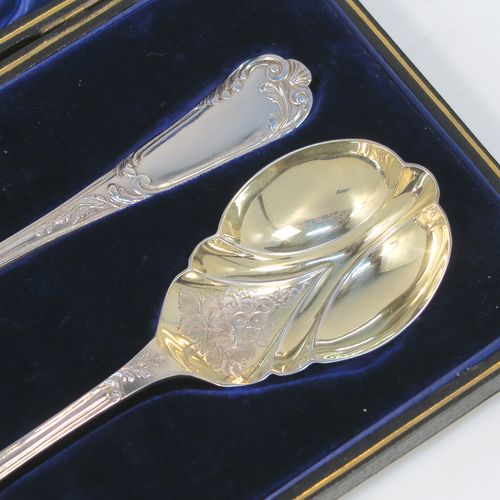 A beautiful pair of Antique Edwardian Sterling Silver serving spoons, having handles with double-struck floral and scroll-work in a Louis style pattern handles, and fluted oval bowls with a gold-gilt wash and hand-engraved floral work, all in their original dark blue satin and velvet-lined presentation box. These wonderful silver serving spoons were made by Thomas Brabury of Sheffield in 1910. The dimensions of this fine hand-made pair of antique silver serving spoons are length 19cms (7.5 inches), and they weigh a total of approx. 97g (3 troy ounces).