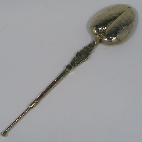A large and beautiful Antique Victorian Sterling Silver and gold-gilt serving spoon, in the Coronation Anointing pattern with hand-engraved floral decoration to the bowl, and a cast ornate and twisted handle. This fantastic silver and gold-gilt Coronation serving spoon was made by Mappin and Webb of London in 1891. The dimensions of this fine hand-made antique silver Coronation Anointing spoon are length 26 cms (10.25 inches), and it weighs approx. 105g (3.4 troy ounce).