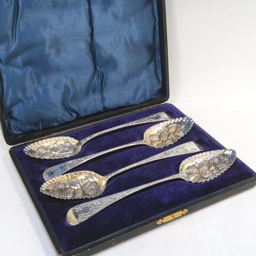 A very pretty set of four Antique Georgian Sterling Silver and gold-gilt berry serving spoons, having hand-chased handles with floral and scroll decoration, and gold-gilt hand-chased fluted bowls with fruit decoration, and all in a blue silk and velvet-lined presentation box. These beautiful antique silver serving spoons were made in London in 1802/03. The dimensions of this fine hand-made set of antique silver berry spoons are length 22.5cms (8.75 inches), and they weigh a total of approx. 213g (6.9 troy ounces).  