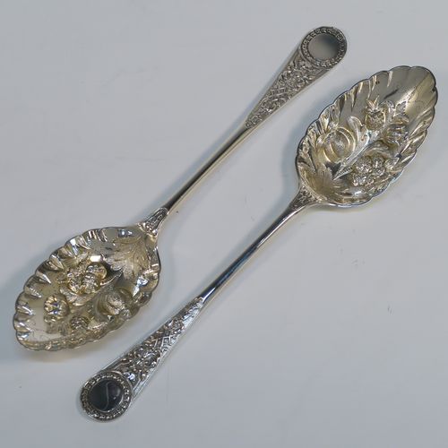 A very pretty pair of Antique Victorian Sterling Silver berry serving spoons, having hand-chased handles with floral decoration, and hand-chased bowls with fluted and fruit decoration, all in their original light blue satin and dark blue velvet-lined presentation box. These beautiful silver serving spoons were made by William Hutton and Sons of London in 1893. The dimensions of this fine hand-made pair of antique silver berry spoons are length 22cms (8.75 inches), and they weigh a total of approx. 146g (4.7 troy ounces).   