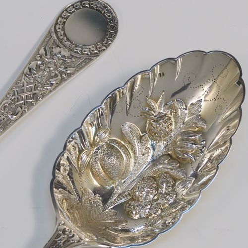 A very pretty pair of Antique Victorian Sterling Silver berry serving spoons, having hand-chased handles with floral decoration, and hand-chased bowls with fluted and fruit decoration, all in their original light blue satin and dark blue velvet-lined presentation box. These beautiful silver serving spoons were made by William Hutton and Sons of London in 1893. The dimensions of this fine hand-made pair of antique silver berry spoons are length 22cms (8.75 inches), and they weigh a total of approx. 146g (4.7 troy ounces).   
