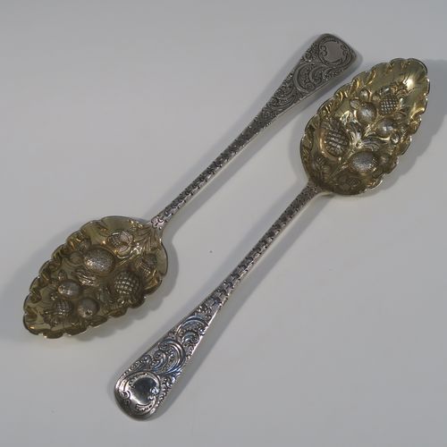 A very pretty pair of Antique Georgian Sterling Silver berry serving spoons, having hand-chased handles with floral and scroll decoration, and hand-chased bowls with gold-gilt fruit decoration, all in their original light blue satin-lined presentation box. These beautiful silver serving spoons were made by William Eley of London in 1782. The dimensions of this fine hand-made pair of antique silver berry spoons are length 22.5cms (8.75 inches), and they weigh a total of approx. 124g (4 troy ounces).   