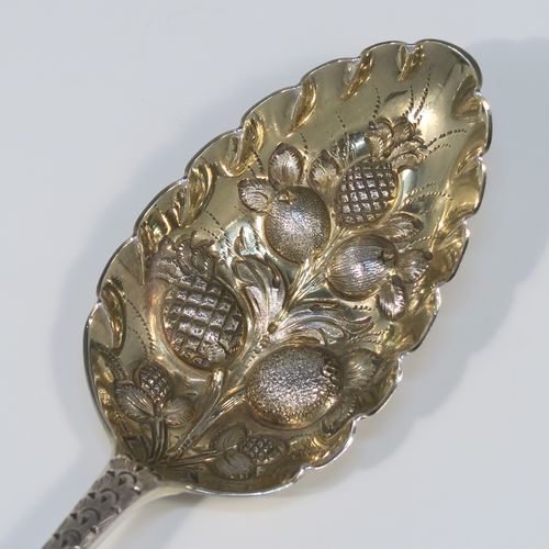 A very pretty pair of Antique Georgian Sterling Silver berry serving spoons, having hand-chased handles with floral and scroll decoration, and hand-chased bowls with gold-gilt fruit decoration, all in their original light blue satin-lined presentation box. These beautiful silver serving spoons were made by William Eley of London in 1782. The dimensions of this fine hand-made pair of antique silver berry spoons are length 22.5cms (8.75 inches), and they weigh a total of approx. 124g (4 troy ounces).   