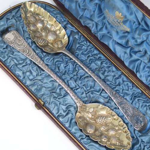 A very pretty pair of Antique Georgian Sterling Silver berry serving spoons, having hand-chased handles with floral and scroll decoration, and hand-chased bowls with gold-gilt fruit decoration, all in their original light blue satin-lined presentation box. These beautiful silver serving spoons were made by William Eley of London in 1782. The dimensions of this fine hand-made pair of antique silver berry spoons are length 22.5cms (8.75 inches), and they weigh a total of approx. 124g (4 troy ounces).   