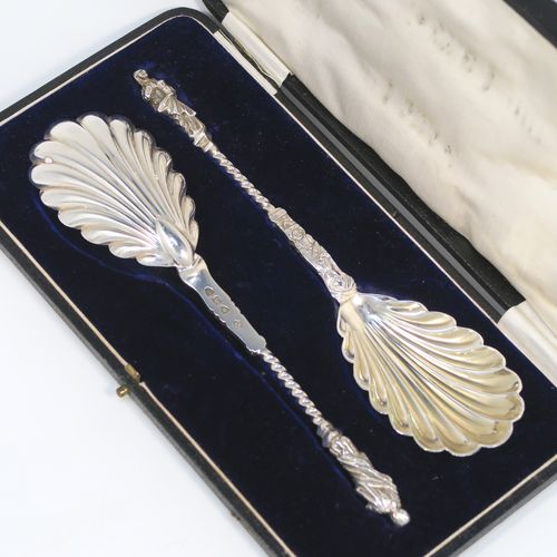 A beautiful pair of Antique Victorian Sterling Silver serving spoons, having cast handles with figural Apostle ends and twisted stems, and fluted oval bowls with a gold-gilt wash. These wonderful silver serving spoons were made by William Hutton and Sons of London in 1894. The dimensions of this fine hand-made pair of antique silver serving spoons are length 20cms (8 inches), and they weigh a total of approx. 130g (4.2 troy ounces).