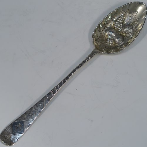 A very pretty pair of Antique Georgian Sterling Silver berry serving spoons, having hand-chased handles with geometric and floral decoration, and hand-chased bowls with fluted and fruit decoration, all in their original purple satin and velvet-lined presentation box. These beautiful silver serving spoons were made by George Burrows of London in 1793. The dimensions of this fine hand-made pair of antique silver berry spoons are length 22.5cms (8.75 inches), and they weigh a total of approx. 109g (3.5 troy ounces).   