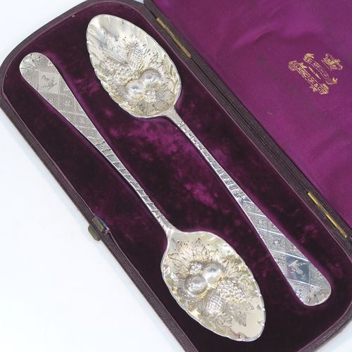 A very pretty pair of Antique Georgian Sterling Silver berry serving spoons, having hand-chased handles with geometric and floral decoration, and hand-chased bowls with fluted and fruit decoration, all in their original purple satin and velvet-lined presentation box. These beautiful silver serving spoons were made by George Burrows of London in 1793. The dimensions of this fine hand-made pair of antique silver berry spoons are length 22.5cms (8.75 inches), and they weigh a total of approx. 109g (3.5 troy ounces).   