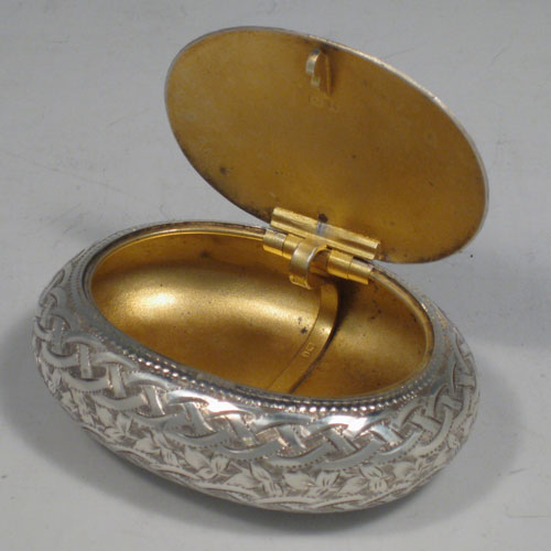 Antique Edwardian sterling silver squeeze-action tobacco box. Having an oval hand-engraved body and gold-gilt interior. Hallmarked for Birmingham in 1908. Length 8 cms (3 inches), width 6 cms (2.25 inches). Weight approx. 50g (1.6 troy ounces).