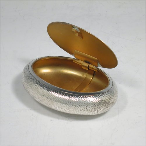 An Antique Edwardian Sterling Silver tobacco box, having an oval body, with engine-turned decoration, a vacant cartouche, a squeeze-action sprung hinged lid, and a gold-gilt interior. Made by Horton & Allday of Birmingham in 1903. The dimensions of this fine hand-made silver tobacco box are length 8 cms (3.25 inches), width 6 cms (2.3 inches), and it weighs approx. 62g (2 troy ounces).