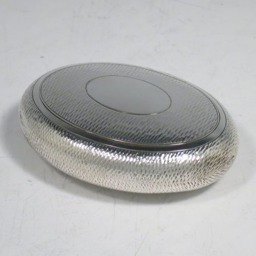 An Antique Edwardian Sterling Silver tobacco box, having an oval body, with engine-turned decoration, a vacant cartouche, a squeeze-action sprung hinged lid, and a gold-gilt interior. Made by Horton & Allday of Birmingham in 1903. The dimensions of this fine hand-made silver tobacco box are length 8 cms (3.25 inches), width 6 cms (2.3 inches), and it weighs approx. 62g (2 troy ounces).