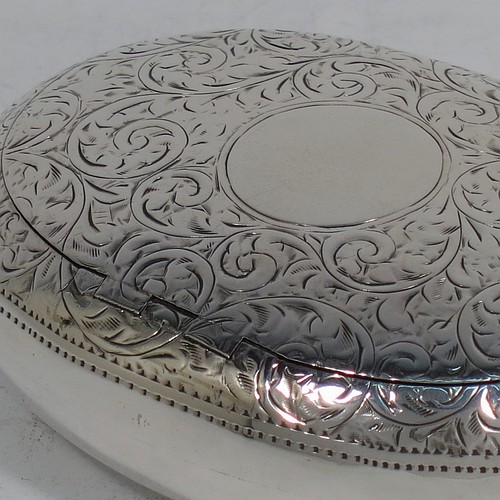A very pretty Antique Edwardian Sterling Silver tobacco box, having an oval body, with hand-engraved floral and scroll decoration, a vacant cartouche, a squeeze-action sprung hinged lid, and a gold-gilt interior. Made by James Round of Birmingham in 1910. The dimensions of this fine hand-made antique silver tobacco box are length 8 cms (3.25 inches), width 6 cms (2.3 inches), and it weighs approx. 78g (2.5 troy ounces).