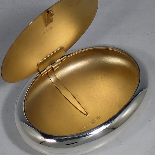 A large Antique Victorian Sterling Silver tobacco box, having a plain oval body with a gold-gilt interior, and squeeze-action sprung hinged lid with flat invisible hinge. Made by Horton & Allday of Birmingham in 1901. The dimensions of this fine hand-made antique silver tobacco box are length 11 cms (4.25 inches), width 8 cms (3.25 inches), depth 2.5 cms (1 inch), and it weighs approx. 119g (3.8 troy ounces).