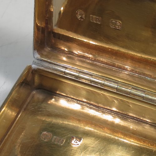 An Antique Georgian Sterling silver large and heavy snuff box, having a rectangular body with engine-turned decoration, with applied cast foliate thumb-piece and borders, and a gold-gilt interior. Made by John Bettridge of Birmingham in 1825. The dimensions of this fine hand-made antique silver snuff box are length 8 cms (3.25 inches), width 5 cms (2 inches), depth 2.5 cms (1.0 inches), and it weighs approx. 156g (5 troy ounces).