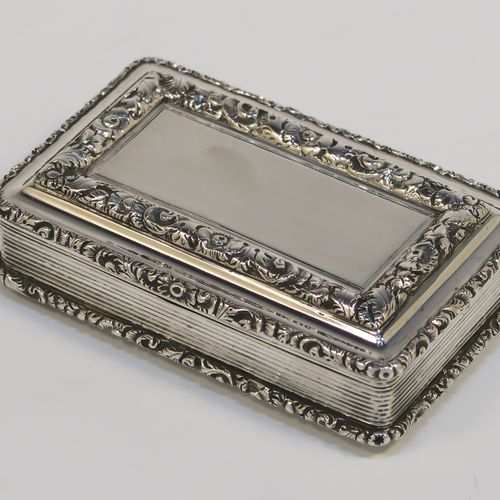 A beautiful Antique late Georgian Sterling silver large and heavy snuff box, having a rectangular body with hand-chased reeded decoration, with applied cast foliate borders, and a gold-gilt interior. This elegant antique silver snuff box was made by Nathaniel Mills of Birmingham in 1834. The dimensions of this fine hand-made antique silver snuff box are length 7 cms (2.75 inches), width 4.5 cms (1.75 inches), depth 2 cms (0.75 inch), and it weighs approx. 94g (3 troy ounces).