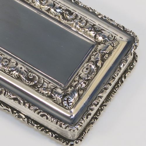 A beautiful Antique late Georgian Sterling silver large and heavy snuff box, having a rectangular body with hand-chased reeded decoration, with applied cast foliate borders, and a gold-gilt interior. This elegant antique silver snuff box was made by Nathaniel Mills of Birmingham in 1834. The dimensions of this fine hand-made antique silver snuff box are length 7 cms (2.75 inches), width 4.5 cms (1.75 inches), depth 2 cms (0.75 inch), and it weighs approx. 94g (3 troy ounces).