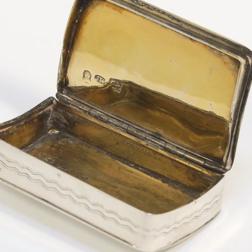 An elegant Antique Georgian Sterling Silver snuff box, having a rectangular body, with a slightly curved profile for holding in a waist-coat pocket, with hand-engraved geometrical & floral decoration, with a vacant rectangular cartouche on one side, a hinged lid and a gold-gilt interior. This beautiful antique silver snuff box was made by Joseph Willmore of Birmingham in 1826. The dimensions of this fine hand-made silver box are length 5.5 cms (2.25 inches), width 3.5 cms (1.3 inches), and it weighs approx. 27g (0.9 troy ounces).