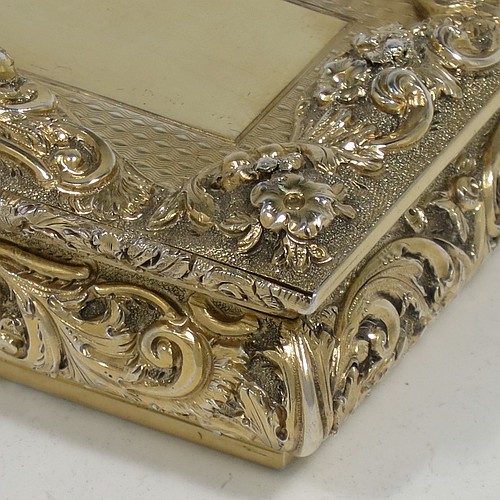 A rare and beautiful Antique Victorian Sterling Silver and gold-gilt large and heavy snuff box, having a rectangular body with applied cast foliate borders, a hinged lid with an applied panel with foliate border and vacant cartouche, the base with an applied panel having hand-engraved foliate & geometrical decoration, the sides with hand-chased floral work. Made by Fredrick Marson of Birmingham in 1848. The dimensions of this fine hand-made antique silver snuff box are length 9 cms (3.5 inches), width 6 cms (2.3 inches), depth 3 cms (1.25 inches), and it weighs approx. 167g (5.3 troy ounces).