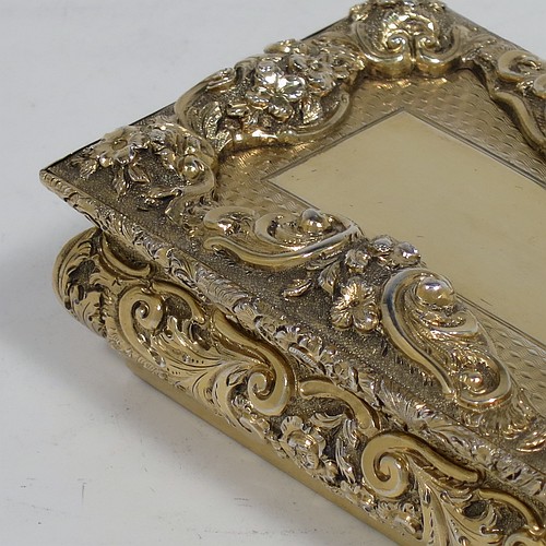 A rare and beautiful Antique Victorian Sterling Silver and gold-gilt large and heavy snuff box, having a rectangular body with applied cast foliate borders, a hinged lid with an applied panel with foliate border and vacant cartouche, the base with an applied panel having hand-engraved foliate & geometrical decoration, the sides with hand-chased floral work. Made by Fredrick Marson of Birmingham in 1848. The dimensions of this fine hand-made antique silver snuff box are length 9 cms (3.5 inches), width 6 cms (2.3 inches), depth 3 cms (1.25 inches), and it weighs approx. 167g (5.3 troy ounces).