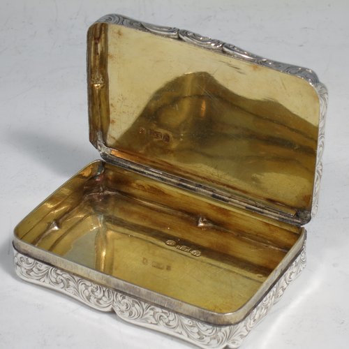 An Antique Victorian Sterling silver large snuff box, having a shaped rectangular body with hand-engraved floral work, an applied cast foliate thumb-piece, and a gold-gilt interior. Made by Nathaniel Mills of Birmingham in 1850. The dimensions of this fine hand-made antique silver snuff box are length 8.5 cms (3.3 inches), width 6 cms (2.3 inches), depth 2 cms (0.6 inches), and it weighs approx. 108g (3.5 troy ounces).   