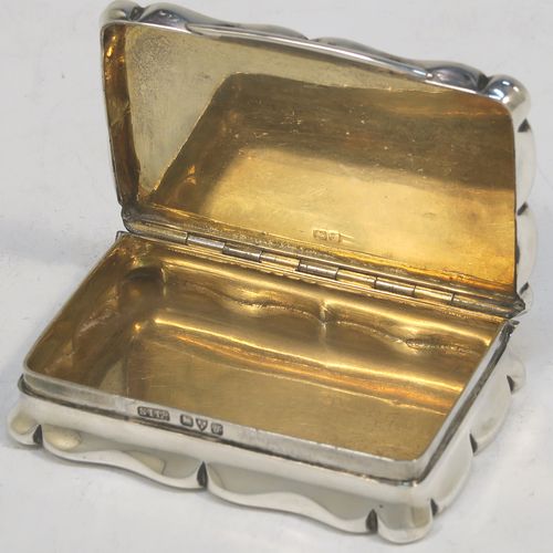 An elegant Antique Sterling silver snuff box, having a shaped rectangular body, a hinged lid with engine-turned decoration and a vacant round cartouche, a gold-gilt interior, and an applied thumb-piece. Made by Stokes and Ireland Ltd., of Chester in 1919. The dimensions of this fine hand-made antique silver snuff box are length 6.5 cms (2.5 inches), width 4.5 cms (1.75 inches), and it weighs approx. 61g (2 troy ounces).   