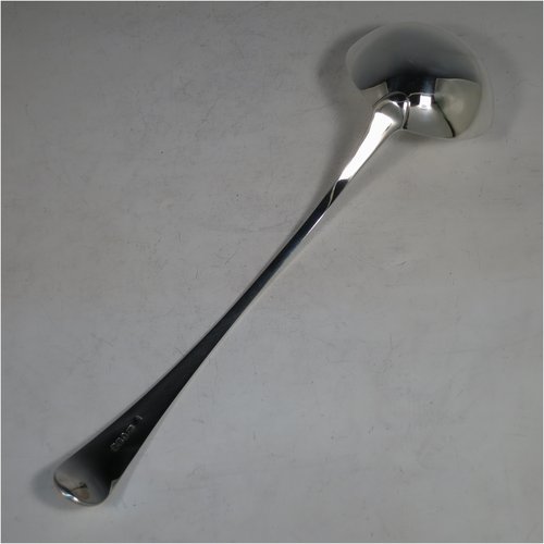 An Antique Georgian Sterling Silver soup ladle in the Old English pattern, having a plain handle with a pip on the reverse, and a plain round bowl with a heel on the reverse. Made by Peter & Anne Bateman of London in 1795. The dimensions of this fine hand-made silver soup ladle are length 34 cms (13.5 inches), and it weighs approx. 185g (6 troy ounces).