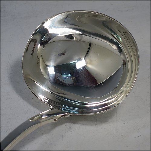An Antique Georgian Sterling Silver soup ladle in the Fiddle pattern, having a plain handle with a pip on the reverse, and a plain round bowl with shoulders above and a heel on the reverse. Made by Sarah & John William Blake of London in 1820. The dimensions of this fine hand-made antique silver soup ladle are length 34 cms (13.5 inches), and it weighs approx. 280g (9 troy ounces).
