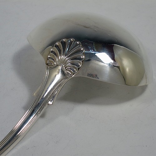 A very handsome and heavy Antique Georgian Sterling Silver soup ladle in the double-struck Kings Hourglass pattern, having a hand-chased shell and hour-glass on the handle, and a plain oval bowl with a shell on the reverse. Made by William Eley of London in 1828. The dimensions of this fine hand-made antique silver soup ladle are length 33 cms (13 inches), and it weighs approx. 270g (8.7 troy ounces).