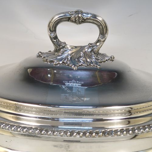 A very handsome Antique Georgian Old Sheffield Plated soup tureen in a Regency style, having an oval plain bellied body with an applied gadroon border, a domed pull-off cover with a cast anthemion leaf handle, with two cast anthemion leaf side handles, and sitting on four cast scroll feet with floral shoulders. This elegant antique Old Sheffield Plated soup tureen and cover was made in ca. 1815. The dimensions of this fine hand-made antique Old Sheffield soup tureen are length (across handles), width 23.5 cms (9.25 inches), height 25.5 cms (10 inches). Please note that this antique Georgian Regency soup tureen is crested on the cover.