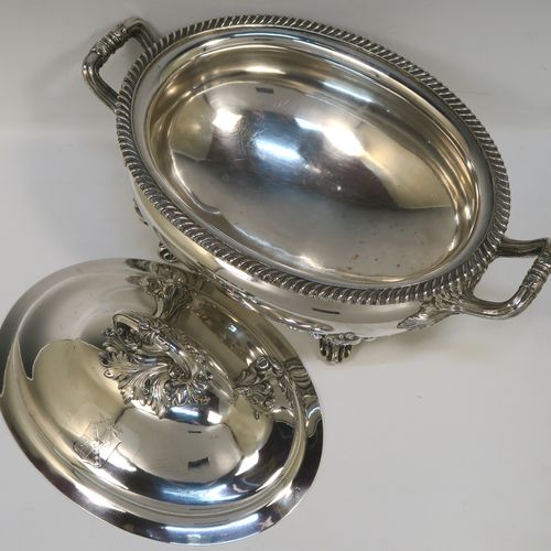 A very handsome Antique Georgian Old Sheffield Plated soup tureen in a Regency style, having an oval plain bellied body with an applied gadroon border, a domed pull-off cover with a cast anthemion leaf handle, with two cast anthemion leaf side handles, and sitting on four cast scroll feet with floral shoulders. This elegant antique Old Sheffield Plated soup tureen and cover was made in ca. 1815. The dimensions of this fine hand-made antique Old Sheffield soup tureen are length (across handles), width 23.5 cms (9.25 inches), height 25.5 cms (10 inches). Please note that this antique Georgian Regency soup tureen is crested on the cover.