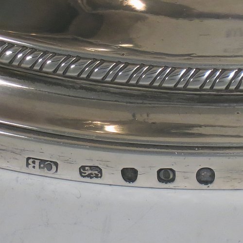 An Antique Georgian Sterling Silver large soup tureen in a boat-shape neoclassical style, having a very plain oval body with a pull-off lid and an urn-shaped finial, with applied gadroon borders, two reeded scroll side-handles, and all sitting on a pedestal foot. Made by Cornelius Bland of London in 1789. The dimensions of this fine hand-made antique silver soup tureen and cover are height 28 cms (11 inches), length including handles 52 cms (20.5 inches), width 25.5 cms (10 inches), and it weighs approx. 2,850g (92 troy ounces).