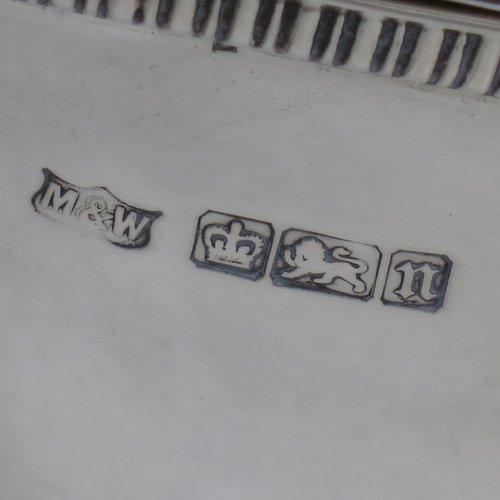 An Antique Edwardian Sterling silver soup tureen, having a pull-off lid with an urn-shaped finial and cut-out slot for a ladle, with hand-chased half-fluted decoration, applied gadroon borders, two reeded scroll side-handles, and all sitting on a pedestal foot. Made by Mappin & Webb of Sheffield in 1905. The dimensions of this fine hand-made antique silver soup tureen and cover are height 25 cms (9.75 inches), length including handles 39.5 cms (15.5 inches), width 21.5 cms (8.5 inches), and it weighs approx. 1,779 (57 troy ounces).